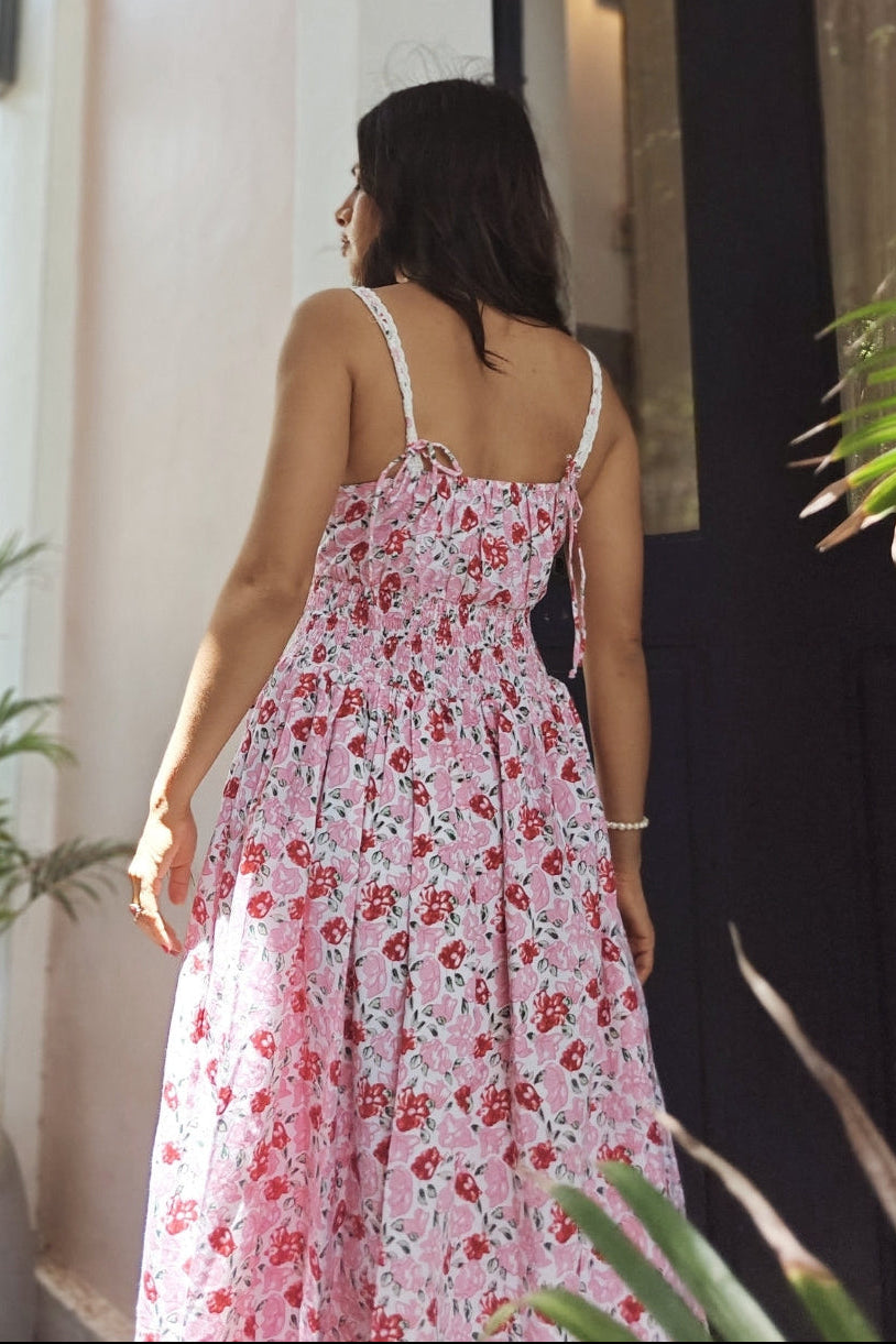 Woman in a floral dress standing in front of a building entrance